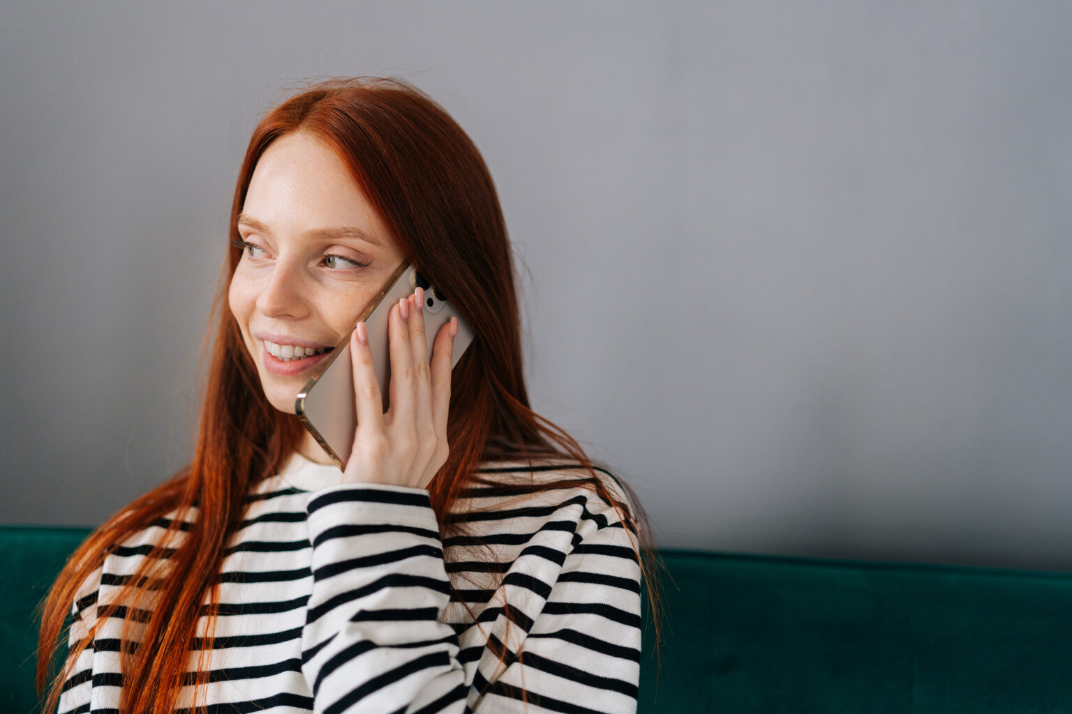 Close-up portrait of happy smiling young woman talking on phone with free calling app