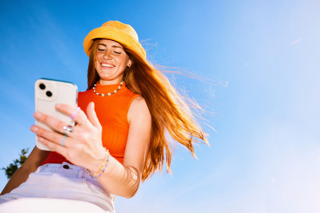 cheerful young woman looking at her free texting and calling app